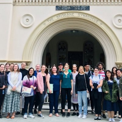 a group of people stand in the arched entrance to a synagogue